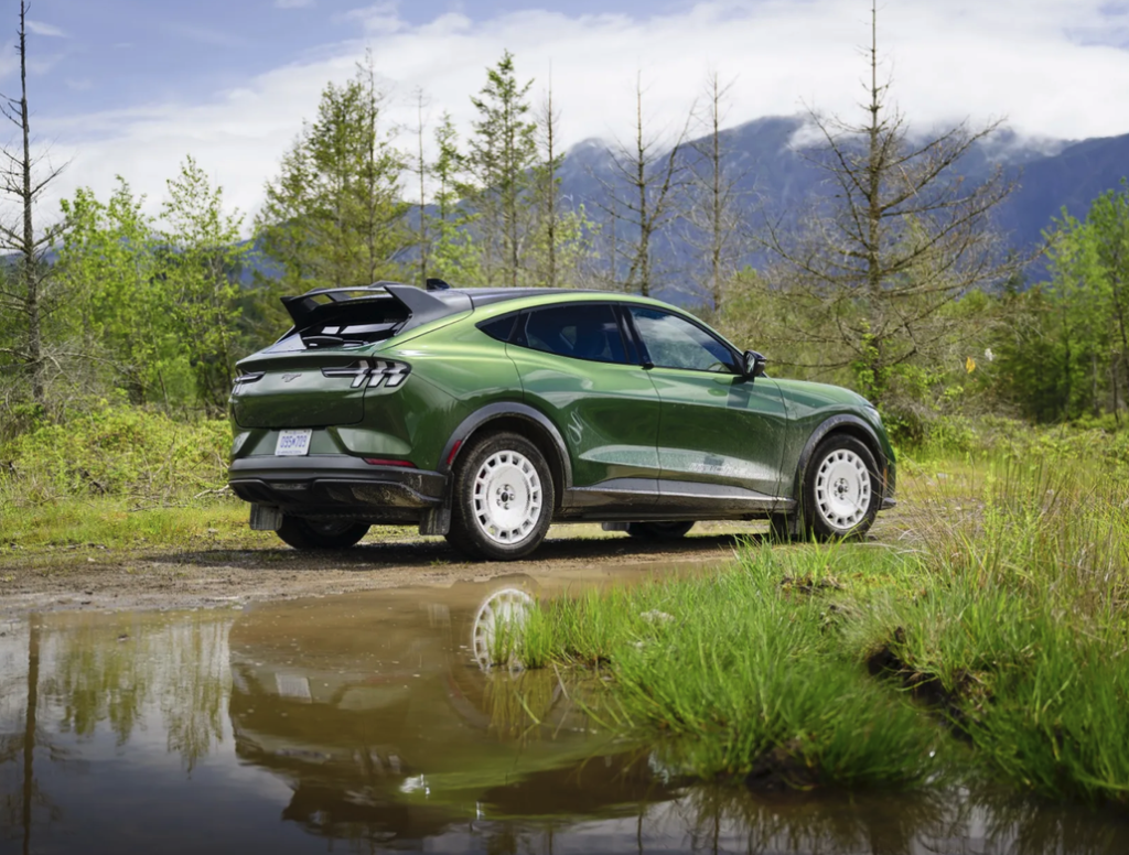 Mustang Mach-E Rally Parked Next to a Forest Creek Rear 3/4 View